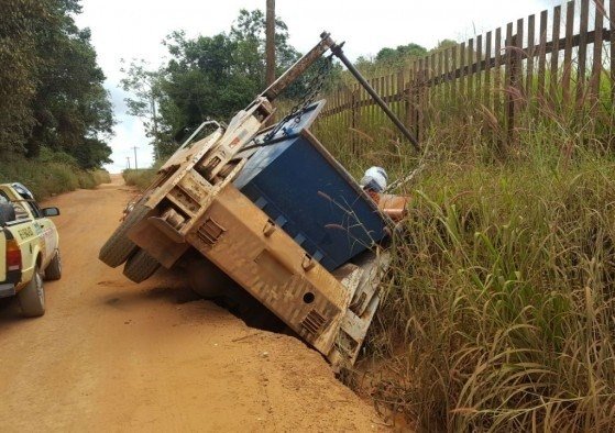 Caminhão fica inclinado ao cair em buraco na estrada que dá acesso ao ‘lixão’